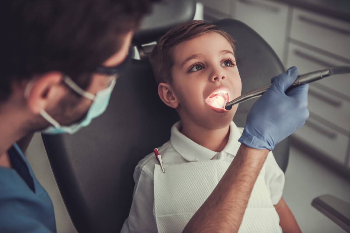 boy open mouth for doctor doing oral examination at medical clinic stock photo