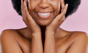 The image shows a close up of a black woman's smile to represent the most common cosmetic procedures.