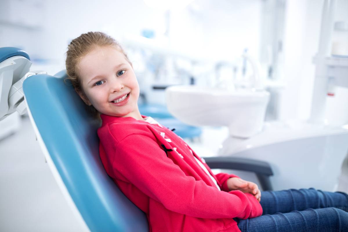Happy girl in dental chair stock photo