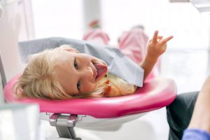 Little girl sitting in the dentists office stock photo