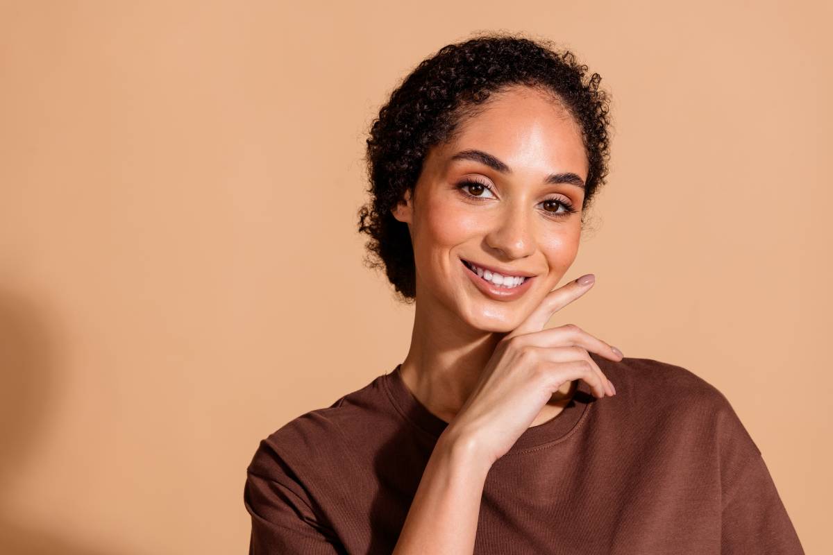 Woman smiling with her hand to her face.